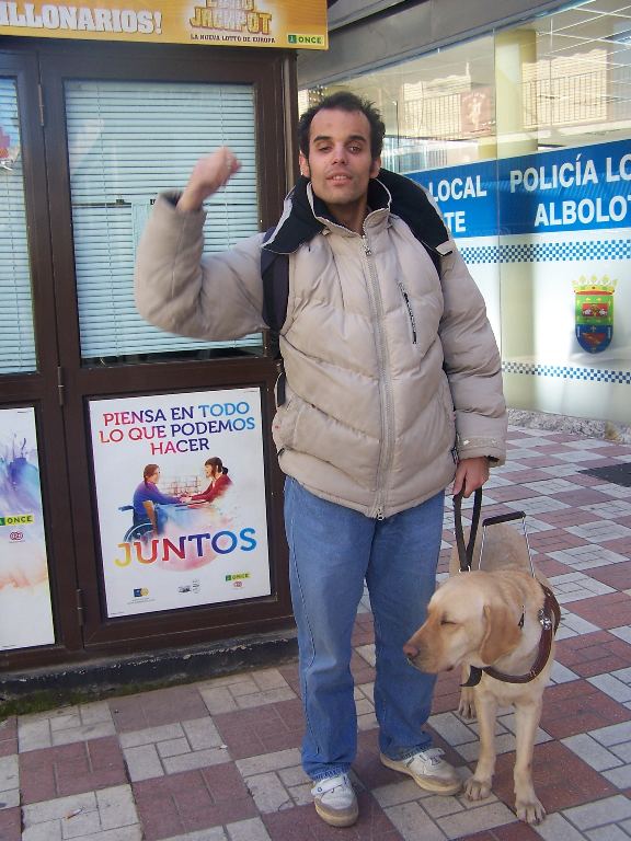 Oscar Linde hace un gesto de victoria junto a su perro guía - Fotografía de Antonio Mansilla
